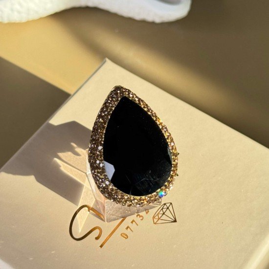 خاتم اسود اللون بشكل دمعة مرصع بشذرات ذهبية اللون و مطلي بماء الذهب